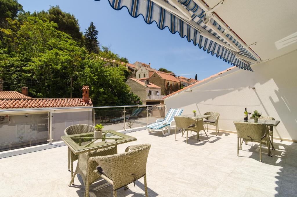 a patio with chairs and tables on a balcony at Rooms &amp; Apartments Barišić in Mlini