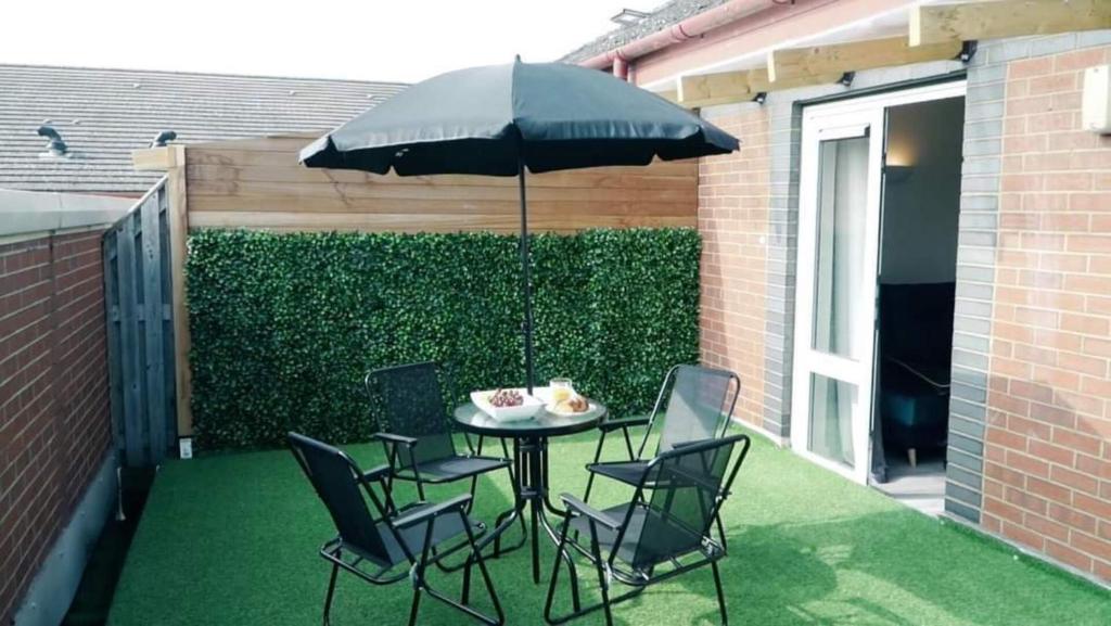 a patio with a table and chairs and an umbrella at Blue Apartment in Peterborough in Peterborough