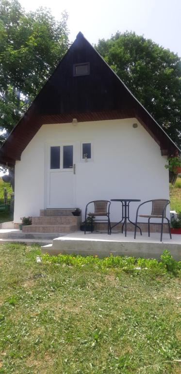 two benches in front of a white building at Durmitorski konak in Žabljak