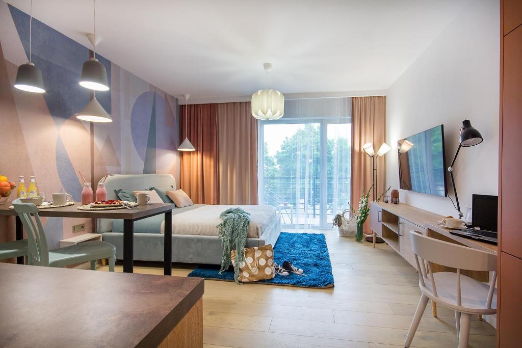 sypialnia z łóżkiem i biurkiem oraz pokój z biurkiem w obiekcie W&K Apartments - Joy Suite w Koszalinie