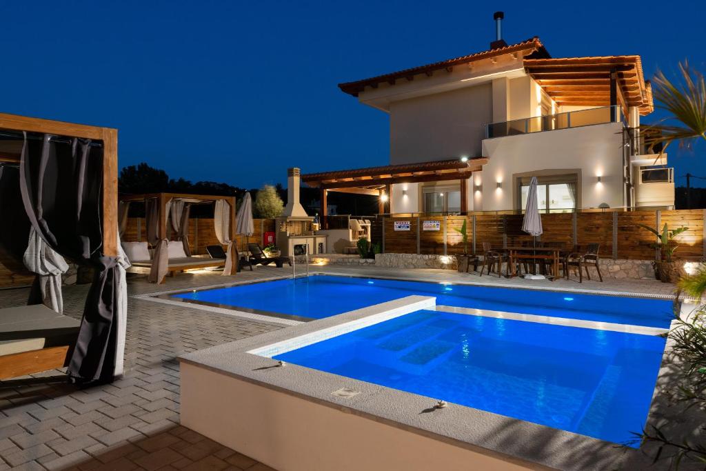 a villa with a swimming pool in front of a house at Panthea Luxury Villa in Ialysos