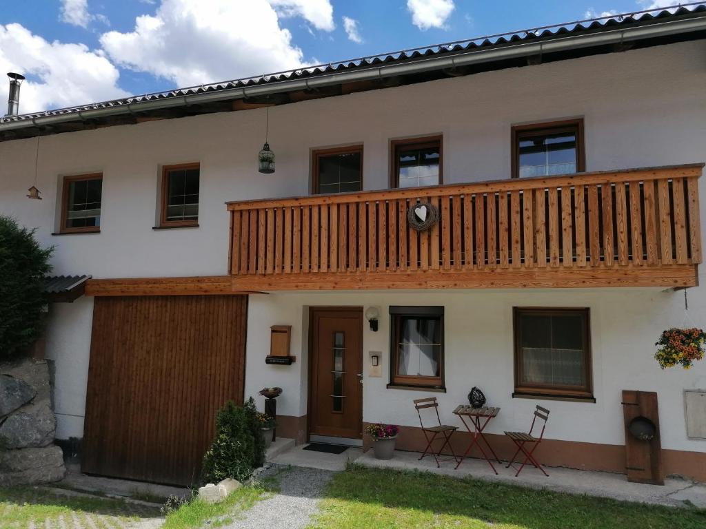 a house with a wooden deck on top of it at Ferienwohnungen Momo in Elbigenalp