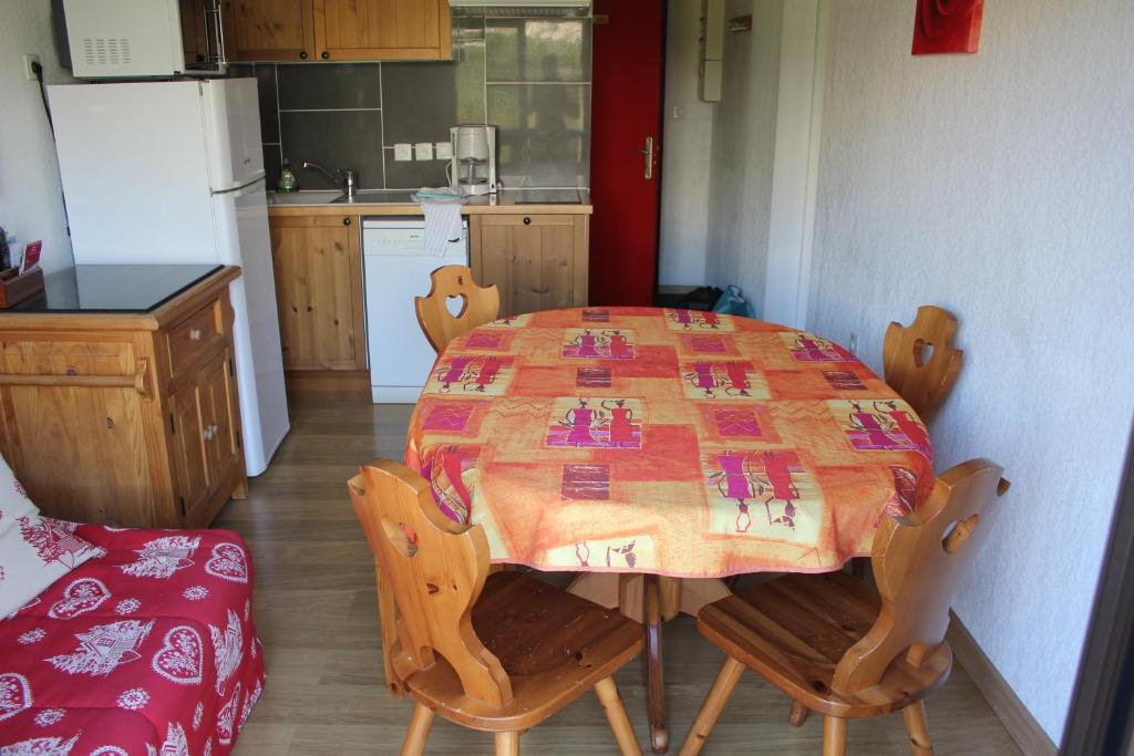 une cuisine avec une table et des chaises ainsi qu'une cuisine avec une table et une table dans l'établissement Appartement Superdévoluy les 4 Géants, à Superdevoluy