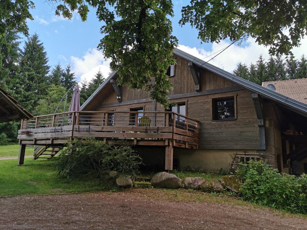 a large wooden house with a large deck at Gite de la Bourbatte in Gerbamont 