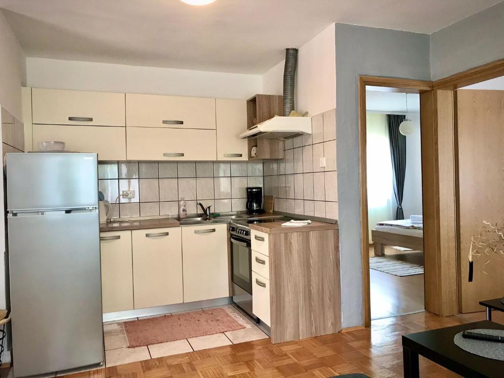 eine Küche mit weißen Schränken und einem Kühlschrank in der Unterkunft Apartment Gabriela in Rakovica