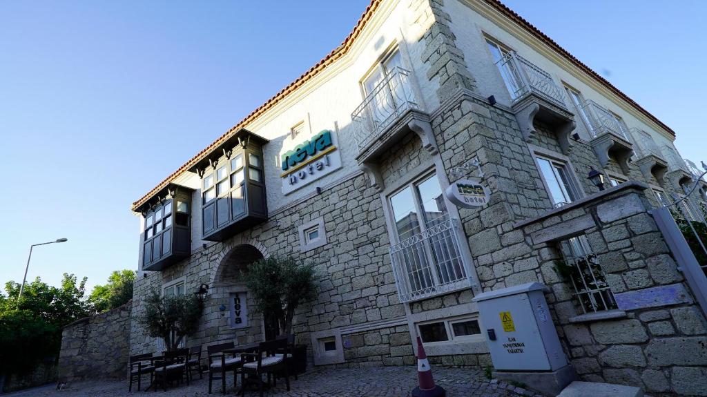 een stenen gebouw met een bord aan de zijkant bij Neva Hotel Alaçatı in Alacati