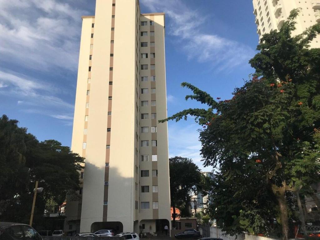un edificio blanco alto con coches estacionados frente a él en 81 · Apto todo Morumbi (5 min-Hosp Einstein), en São Paulo