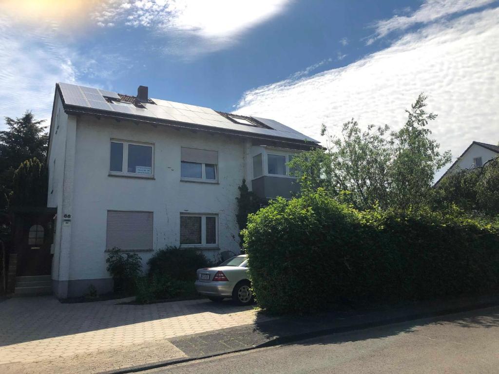 a white house with a car parked in front of it at Ferienwohnung Horn in Kirchlengern