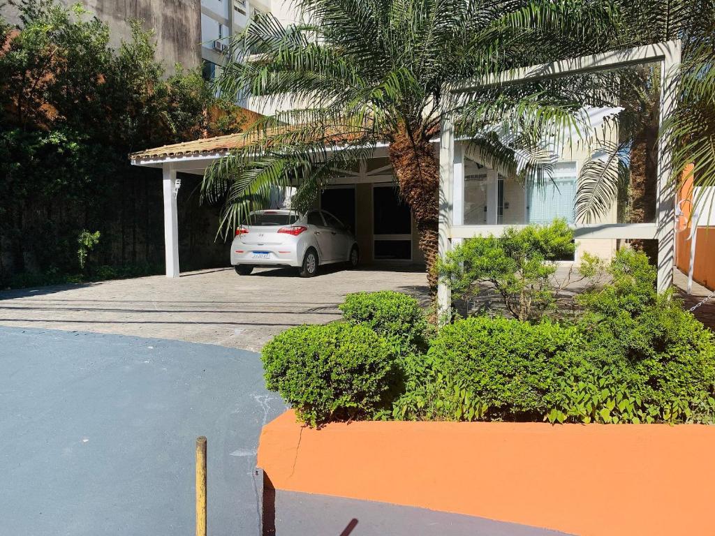 a white car parked in front of a house at POUSADA MUNDI MORUMBI in Sao Paulo