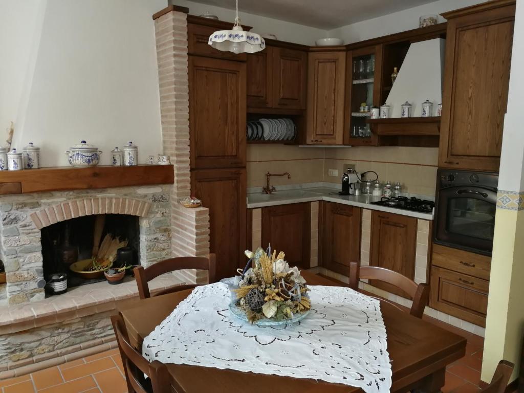 a kitchen with a table and a fireplace at La Casetta Di Chichi E Lory in Stazzema