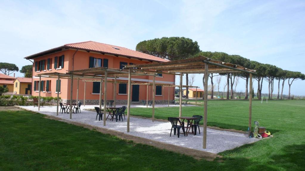 a group of tables and chairs in front of a building at La Fattoria di Tirrenia in Tirrenia