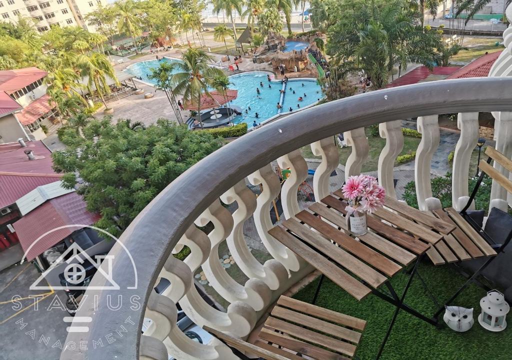 a balcony with a bench and a swimming pool at Port Dickson 6pax 2BR Glory Beach Resort Seaview in Port Dickson