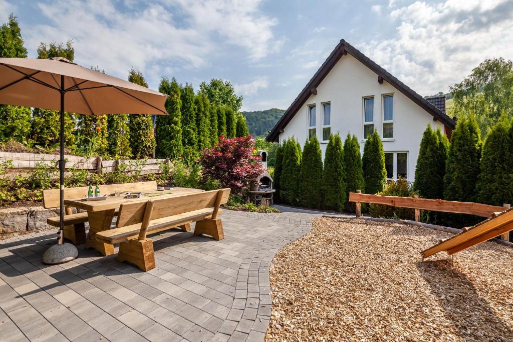 a patio with a table and an umbrella at Ols Berghaus in Olsberg