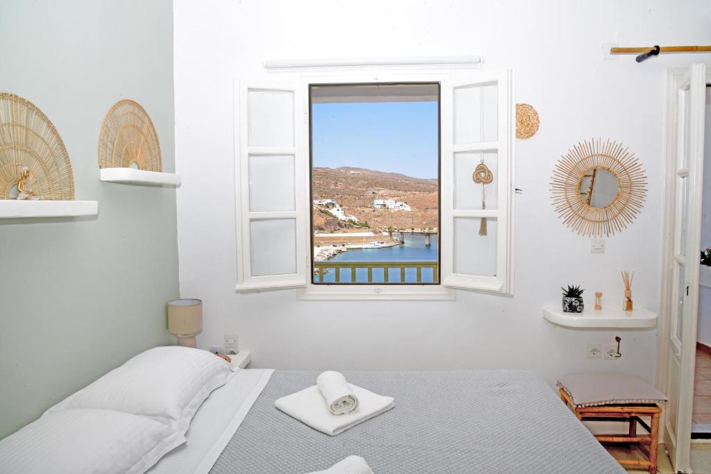 1 dormitorio con cama y ventana en NEFELI SUITES KYTHNOS, en Loutra