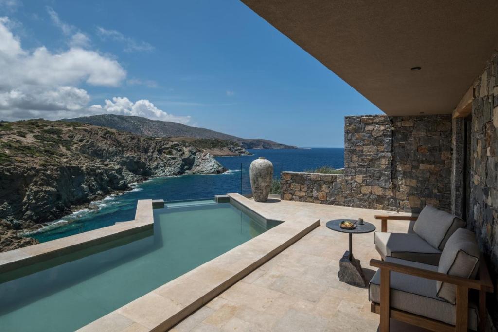 a house with a swimming pool with a view of the ocean at Acro Suites - A Wellbeing Resort in Agia Pelagia