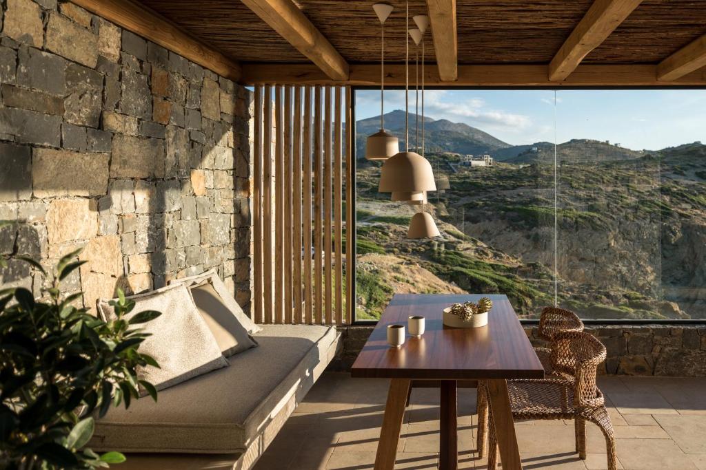 a living room with a couch and a table at Acro Suites - A Wellbeing Resort in Agia Pelagia