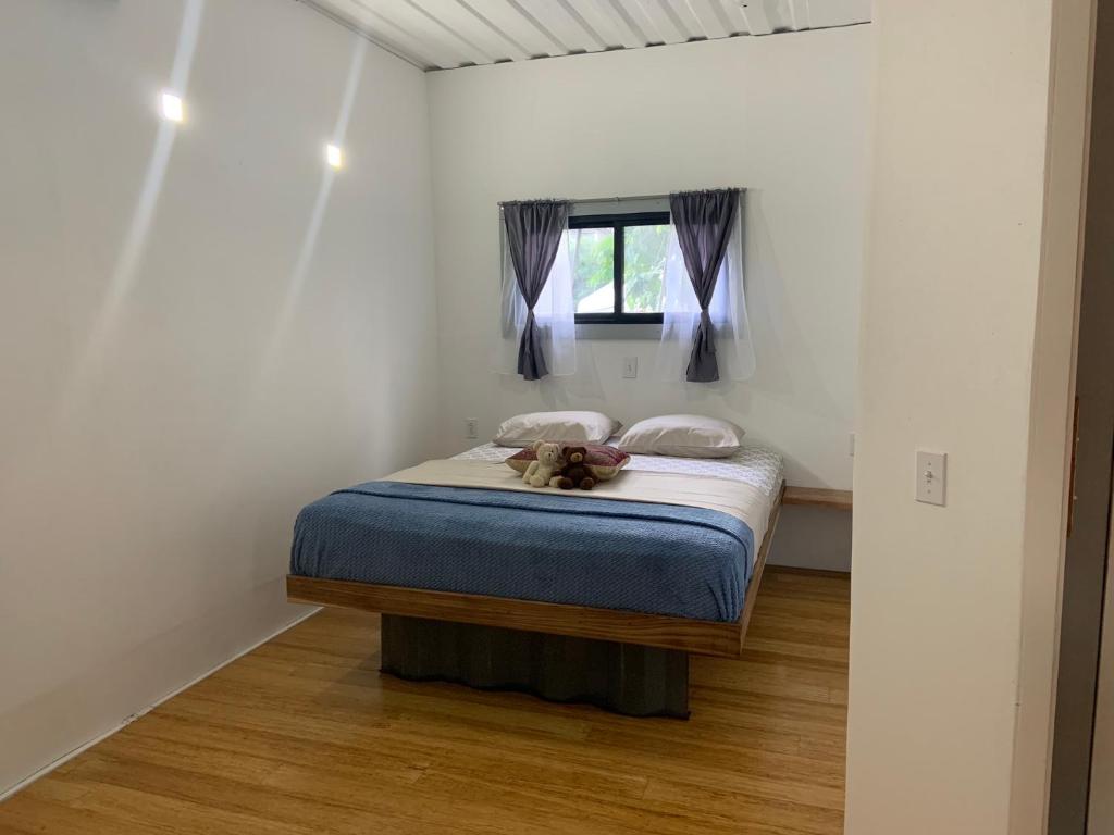 um quarto com uma cama com um cão sentado nela em Apartment House Boquete Palmira Apartment 3 em Boquete