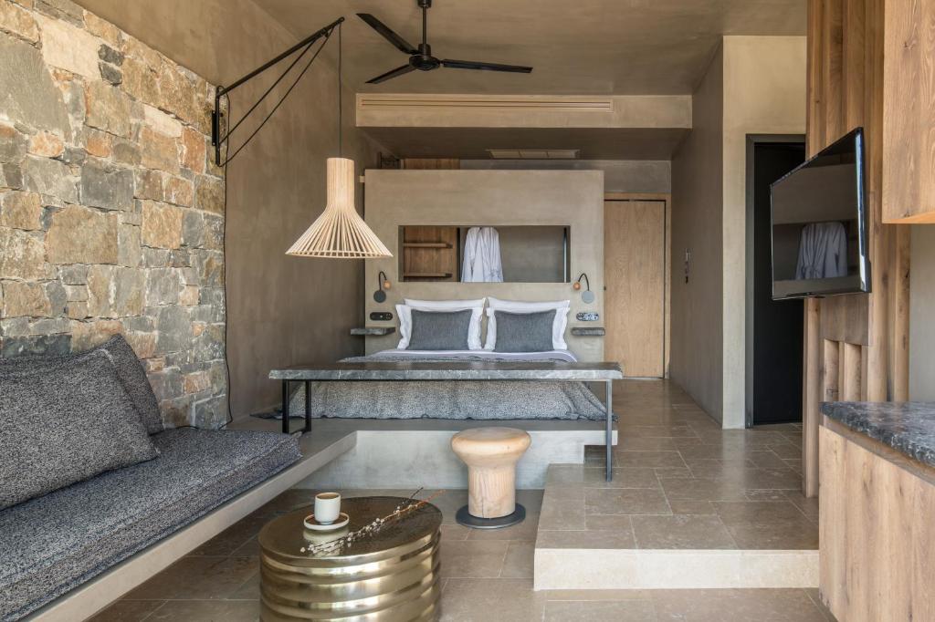 a bedroom with a bed and a couch at Acro Suites - A Wellbeing Resort in Agia Pelagia