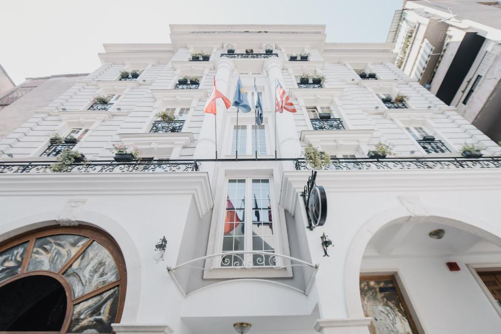 a large building with a clock on the front of it at Lot Boutique Hotel by Hotels and Préférence in Tirana