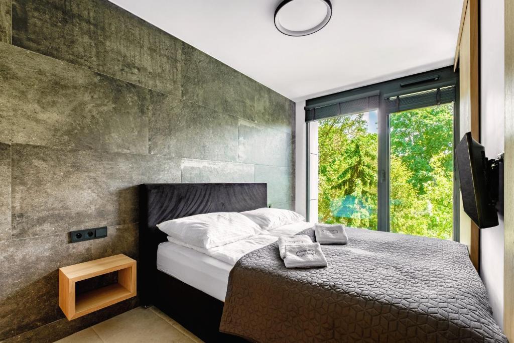 a bedroom with a bed with a concrete wall at Apartamenty Premium NJ Lublin Centrum Basen & SPA in Lublin