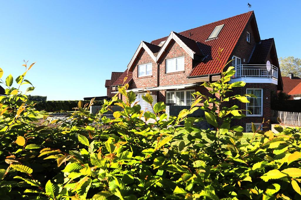 een groot bruin huis met een rood dak bij Gästehaus Sam in Bad Sassendorf