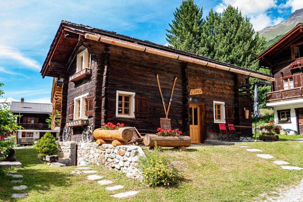 une maison en rondins avec un jardin en face de celle-ci dans l'établissement Izba, à Zinal