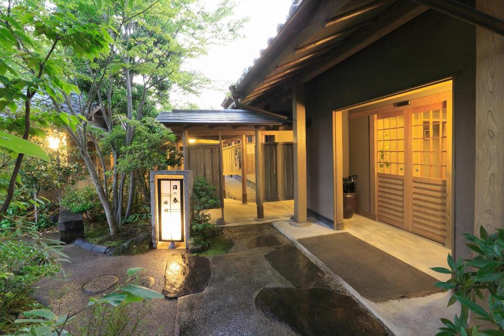 une maison avec une passerelle menant à la porte d'entrée dans l'établissement Yufuin Onsen Hinoharu Ryokan, à Yufu
