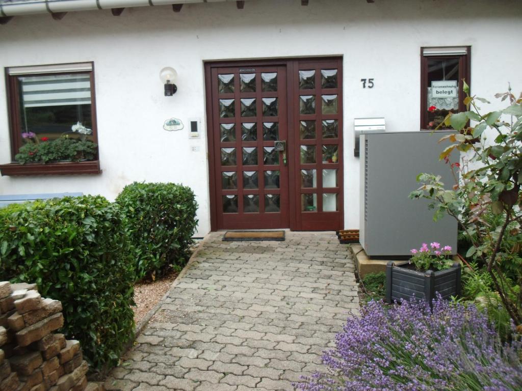 uma casa com uma porta de madeira e um passadiço de tijolos em Haus Rosi em Weiskirchen