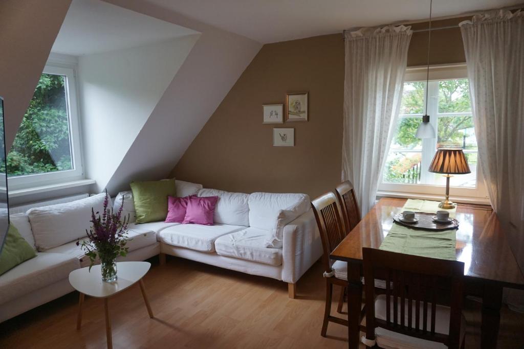 ein Wohnzimmer mit einem weißen Sofa und einem Tisch in der Unterkunft Mirabella in Lüneburg