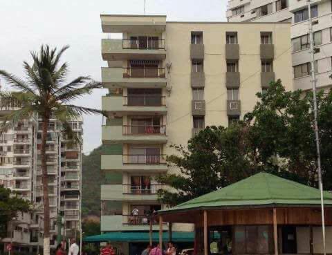 un edificio alto con una palma di fronte di Apartamento Oasis a Puerto de Gaira