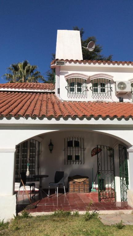 a white house with a red roof and a patio at Chenin Lodge in Ciudad Lujan de Cuyo