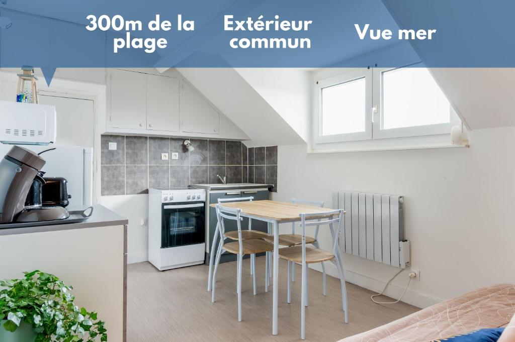 a kitchen with a table and chairs in a room at Appartement à 300m de la plage - Extérieur commun in Asnelles