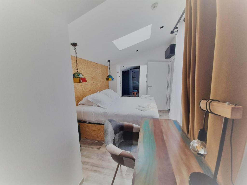 a room with a bed and a table with a chair at Résidence La Chaize in Noirmoutier-en-l'lle