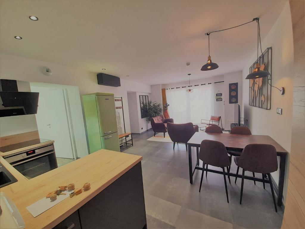 a kitchen and living room with a table and chairs at Résidence La Chaize in Noirmoutier-en-l'lle