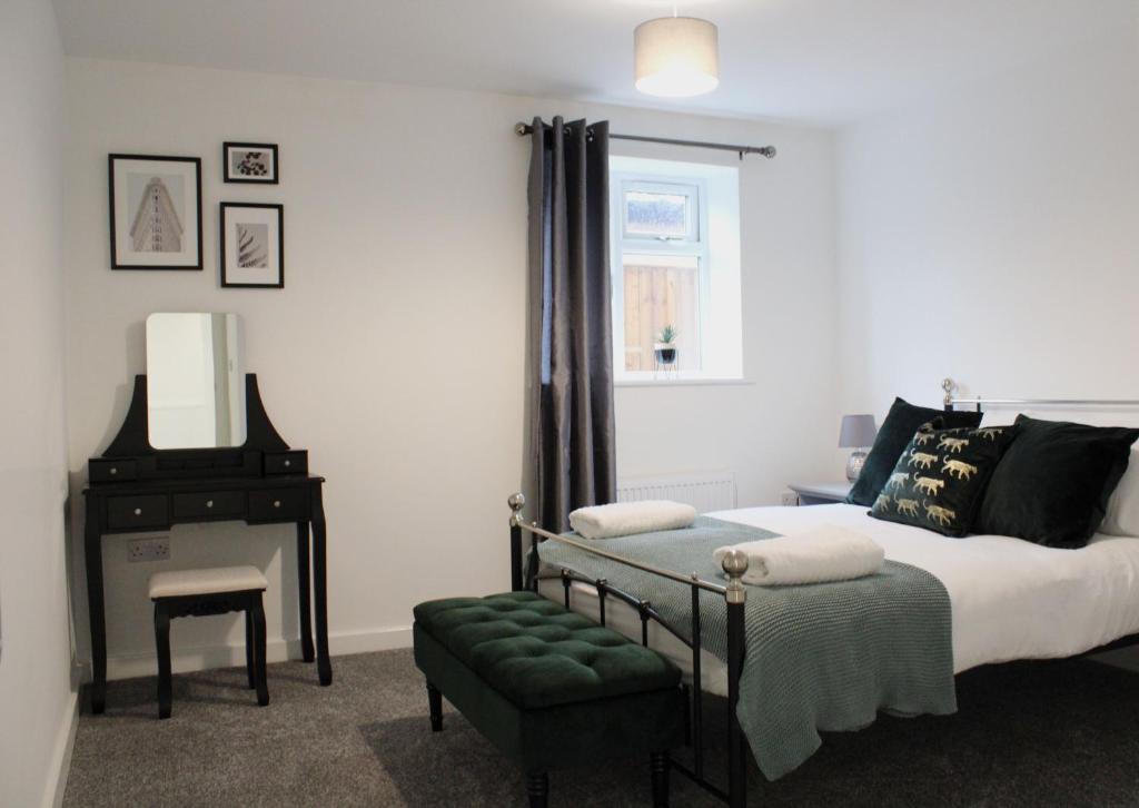 a bedroom with a bed and a mirror and a piano at Didcot - Private Flat with Garden & Parking 08 in Didcot