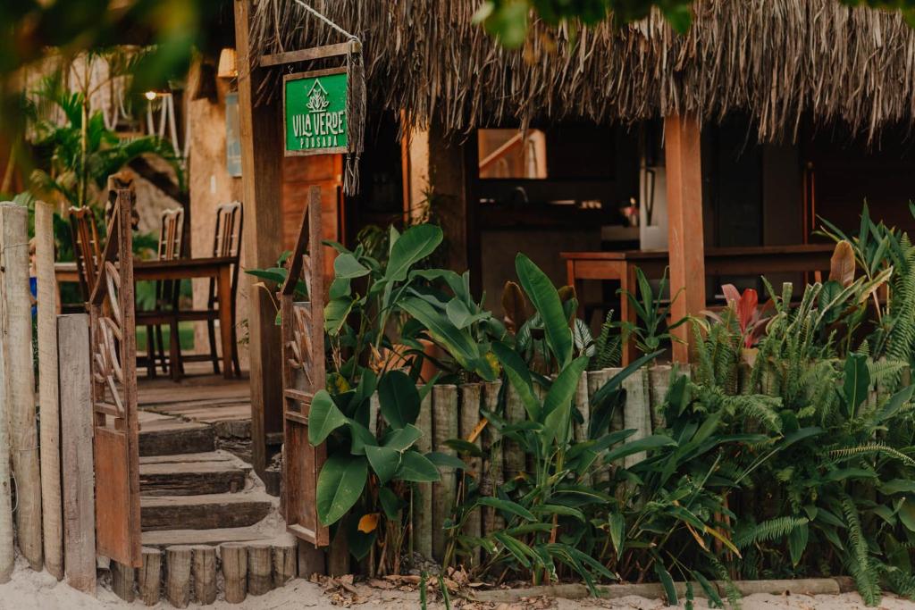 um edifício de resort com uma placa com plantas em Pousada Vila Verde Caraíva em Caraíva