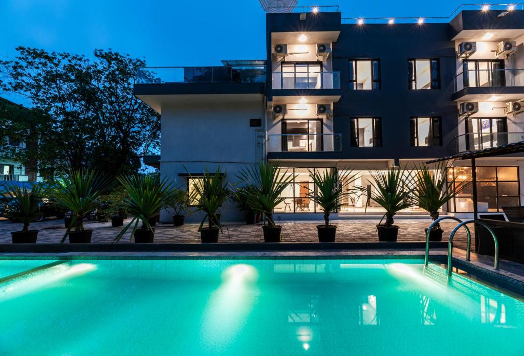 a swimming pool in front of a building at night at Le Papillon By Bay Hotels in Lonavala