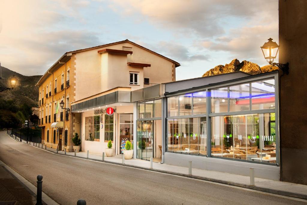 ein Gebäude mit Glasfenstern an der Straßenseite in der Unterkunft Hotel Parras Arnedillo in Arnedillo