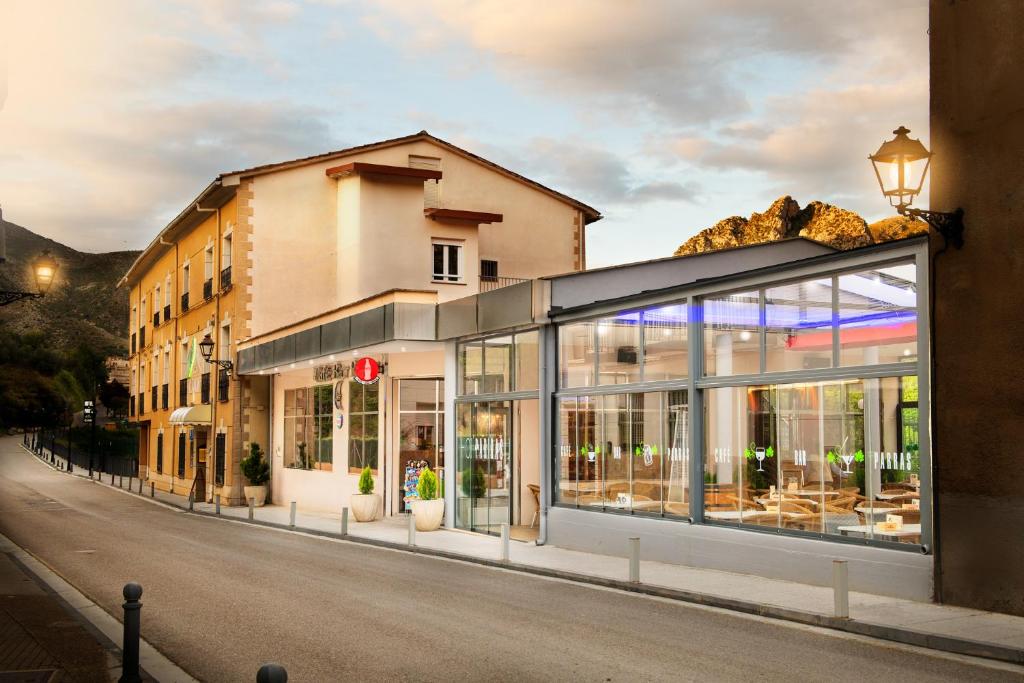un bâtiment avec des fenêtres en verre sur le côté d'une rue dans l'établissement Hotel Parras Arnedillo, à Arnedillo