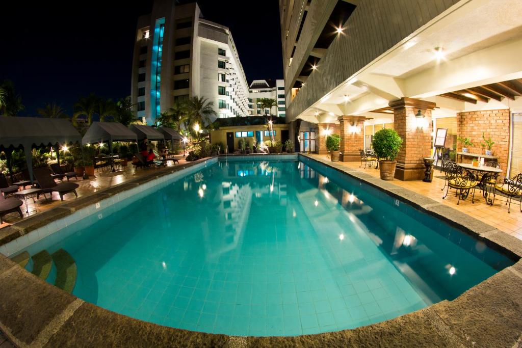 a large swimming pool in a hotel at night at Copacabana Apartment Hotel - Staycation is Allowed in Manila