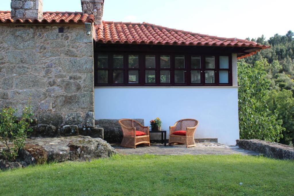 um pátio com duas cadeiras e uma mesa em frente a um edifício em Casa das Saras em Gonçalo
