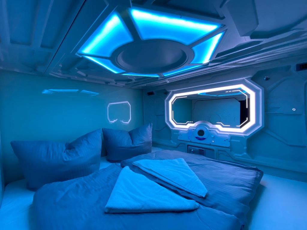 a blue room with a bed and a tv at Space Night Capsule Hostel in Berlin