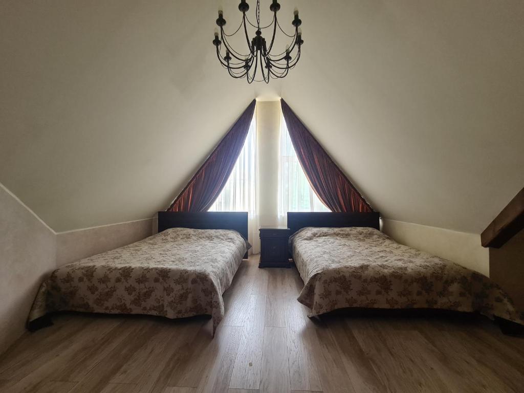 two beds in a room with a large window at Meldynas in Vabalninkas