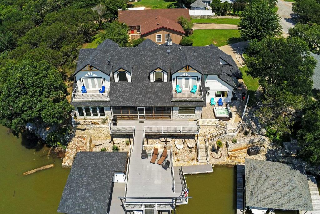 an aerial view of a large house on the water at Lavish Lake House, Near Vineyards and Marinas! in Granbury