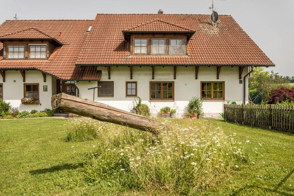 ein Haus mit einem gefallenen Baum im Hof in der Unterkunft Hof Wagenberg Ferienwohnung 1 in Deggenhausertal