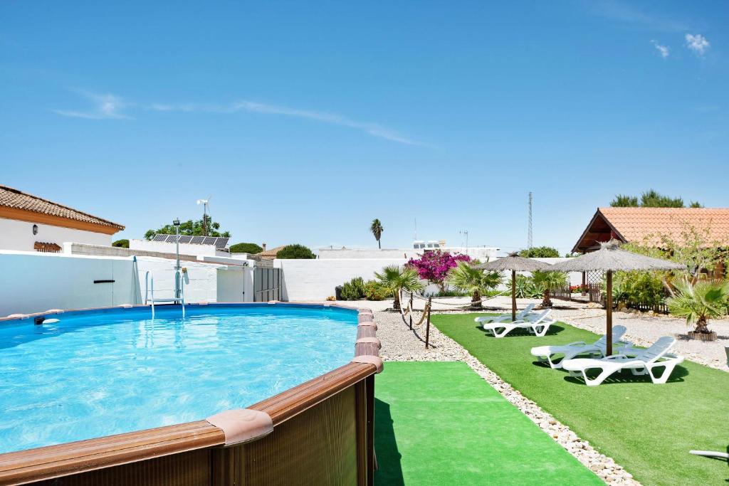 - une piscine sur un balcon avec pelouse et parasols dans l'établissement El Viajero, à Roche