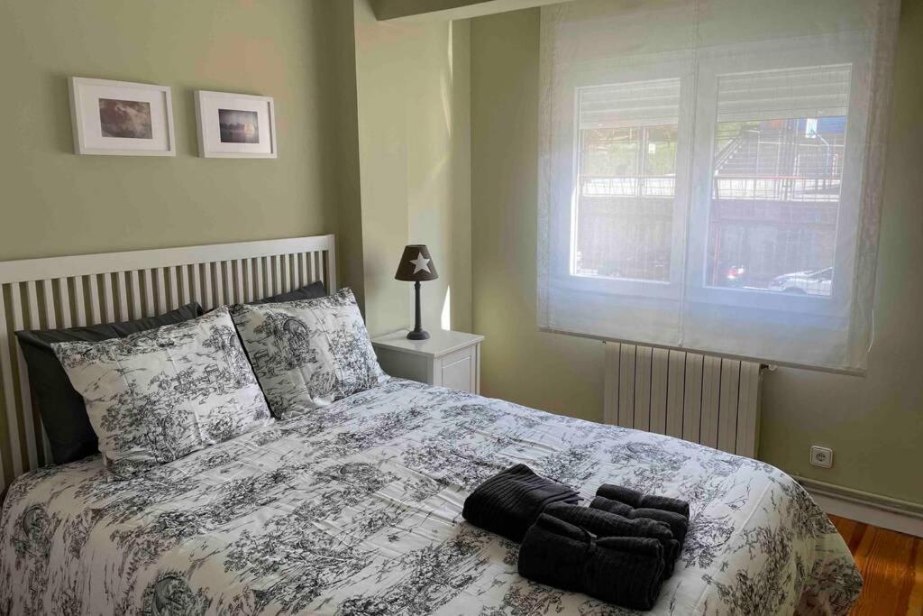 a bedroom with a bed with a black and white comforter at Coqueto apartamento cerca de la playa in Santander