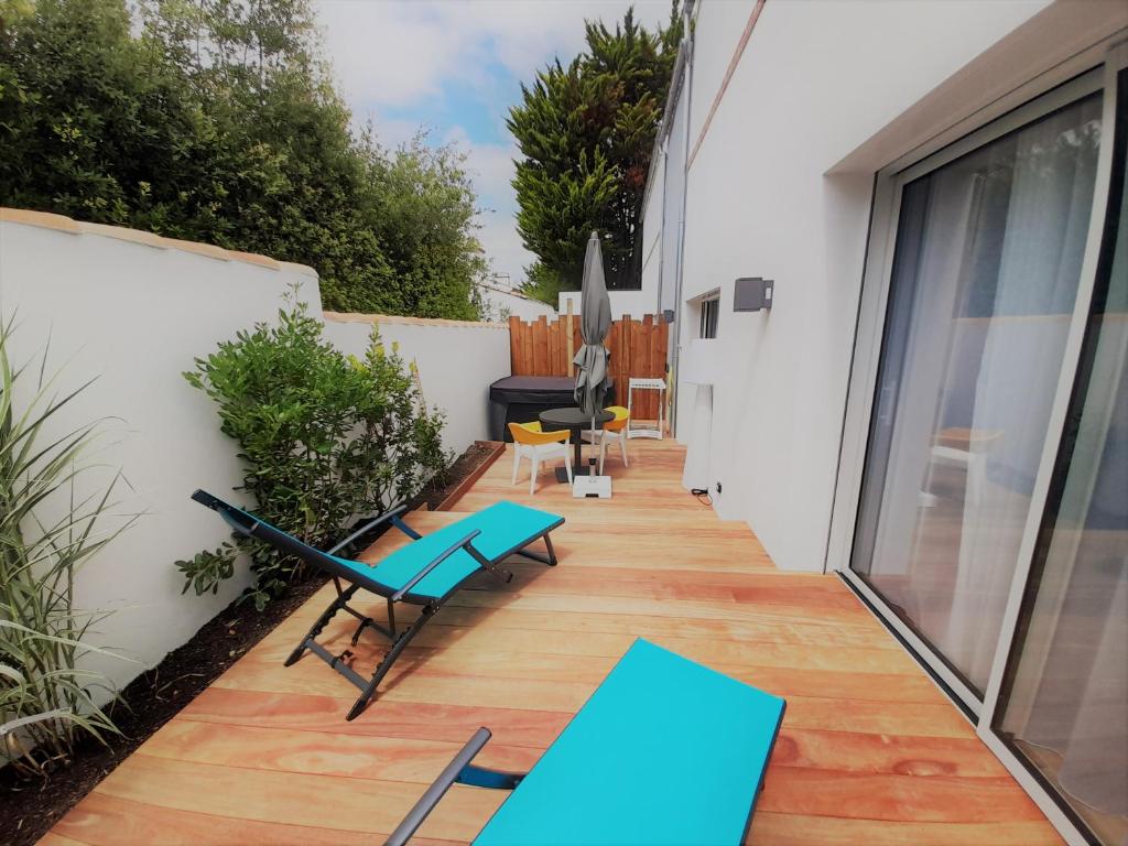 a patio with a blue table and chairs on a building at Résidence La Chaize in Noirmoutier-en-l'lle