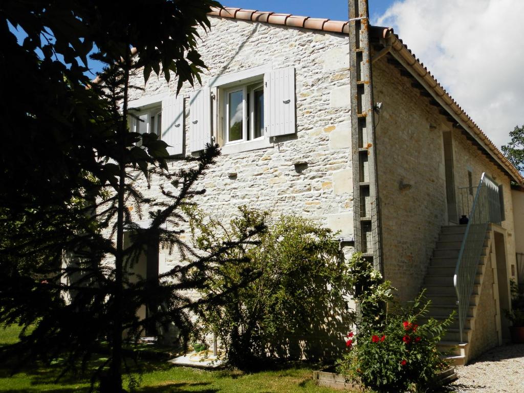 uma casa de tijolos brancos com uma janela e escadas em Au pré du Mignon aux portes du Marais Poitevin em Thorigny