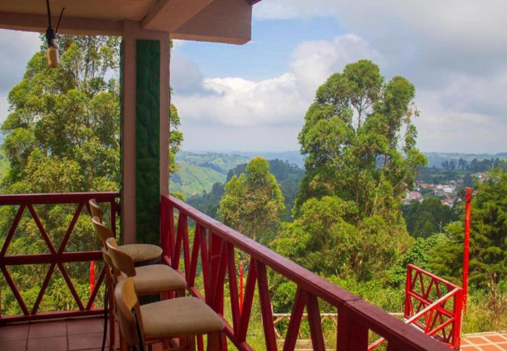 a balcony with a chair and a view of trees at Hotel Natura Cocora in Salento